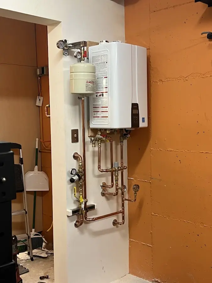 Plumbing technician inspecting water heater connections in Lunenburg